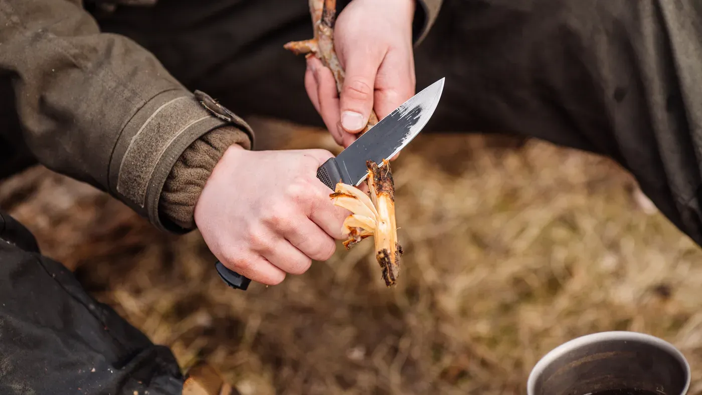 Jägare flår vilt med kniv i fält
